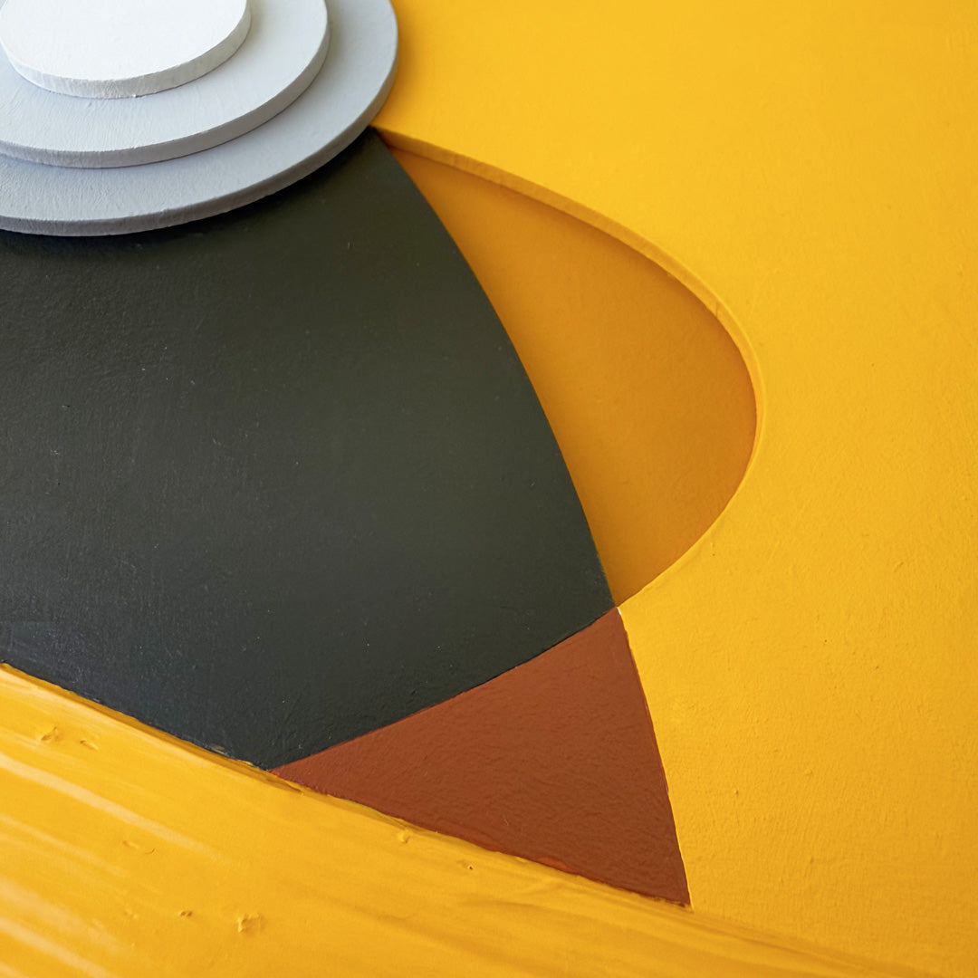 Close-up of abstract yellow and brown Pikachu art piece with geometric cut out shapes.