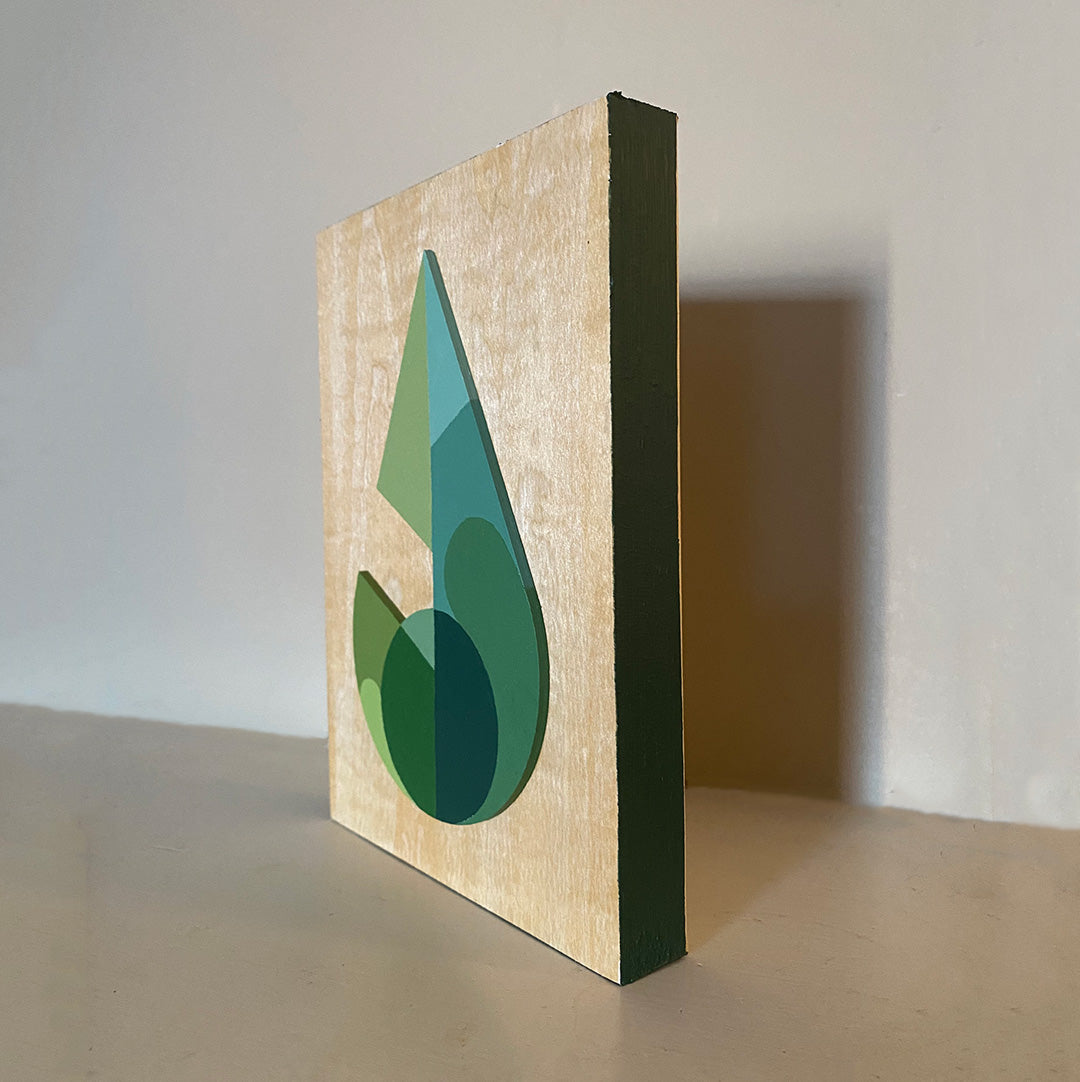 Wooden panel with dimensional laser cut green abstract leaf design on a neutral background