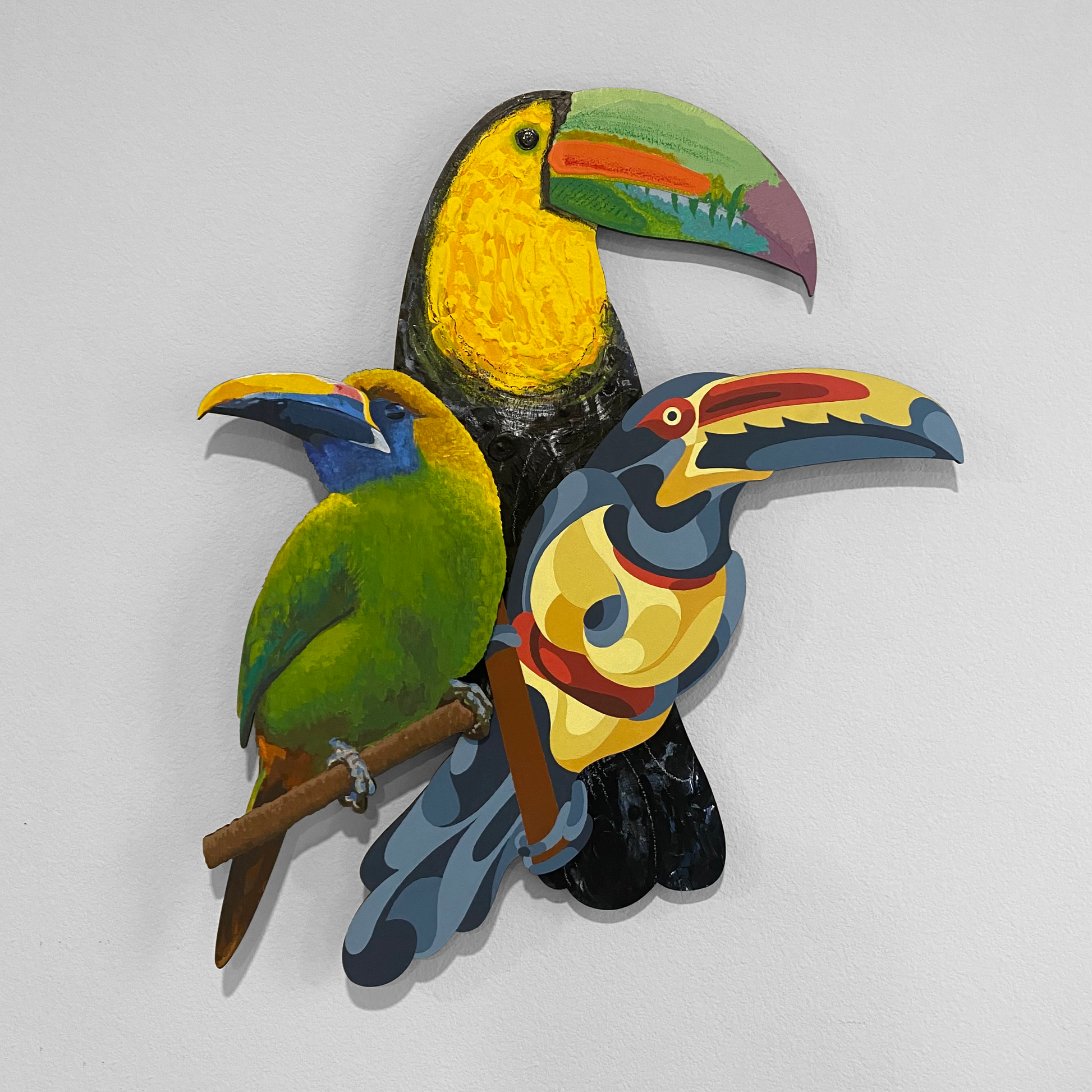 Trio of colorful, dimensional wooden toucans painted in abstract acrylic styles. One is very realistic, another is filled with organic shapes, and the largest with thick paint layers and oil crayon details.