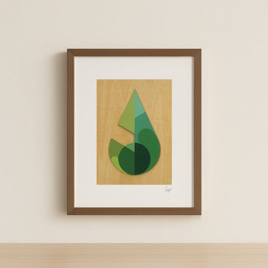 Framed abstract green geometric leaf art print on a wood grain background with a simple walnut frame.