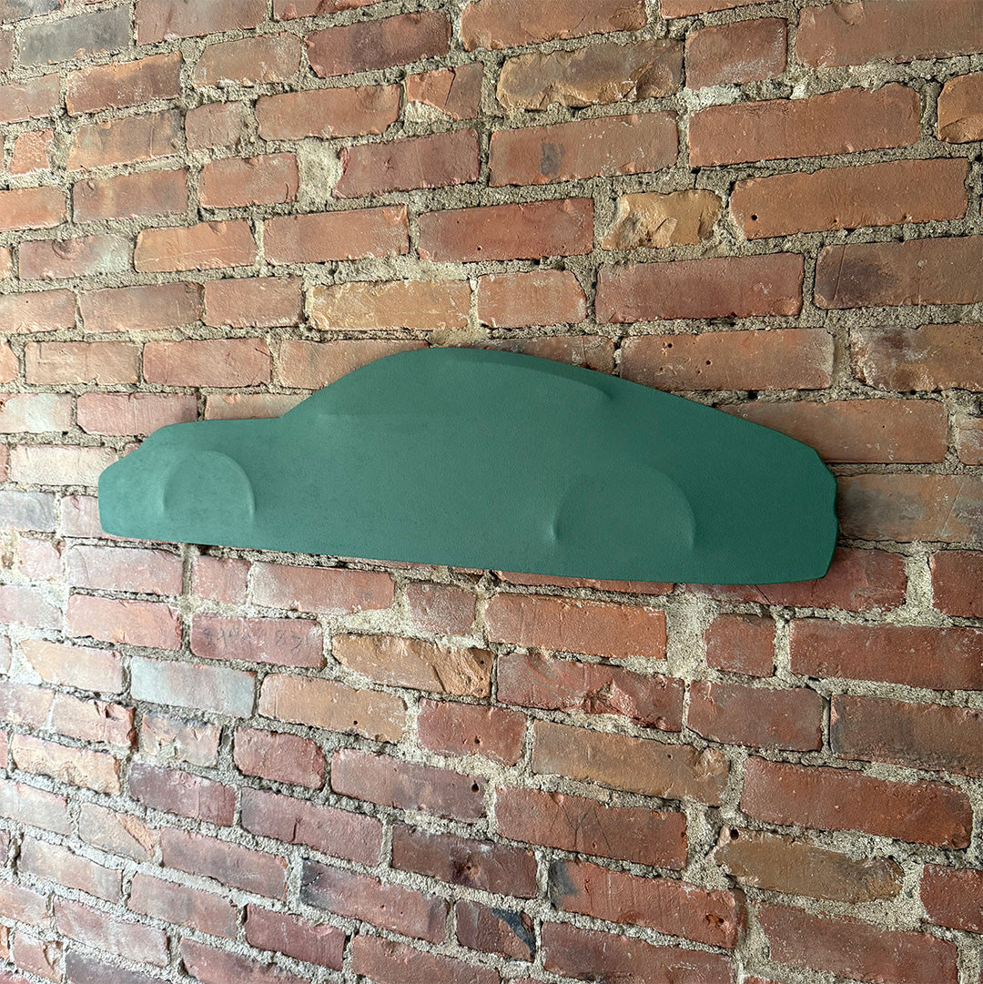 Side view of car silhouette, custom stretched canvas wall art with single green color tone hanging on a white wall.