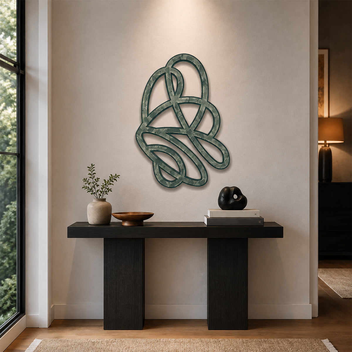 Abstract sage green flowing knot design wood wall art displayed above a modern black console table in a minimalist entryway with warm neutral walls, soft natural light, and curated decorative accents.