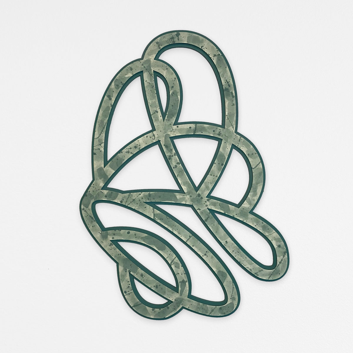 A decorative abstract knot 3D wall art design with a green and gray paint splatter pattern, hanging on a light gray background.