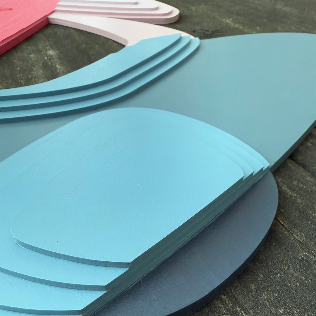 Close-up detailed photo of light blue painted wood layered resting on a tabletop.