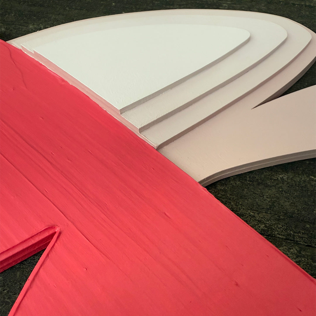 Close-up detailed photo of pastel pink painted wood layered art with textured fluorescent pink color accents.