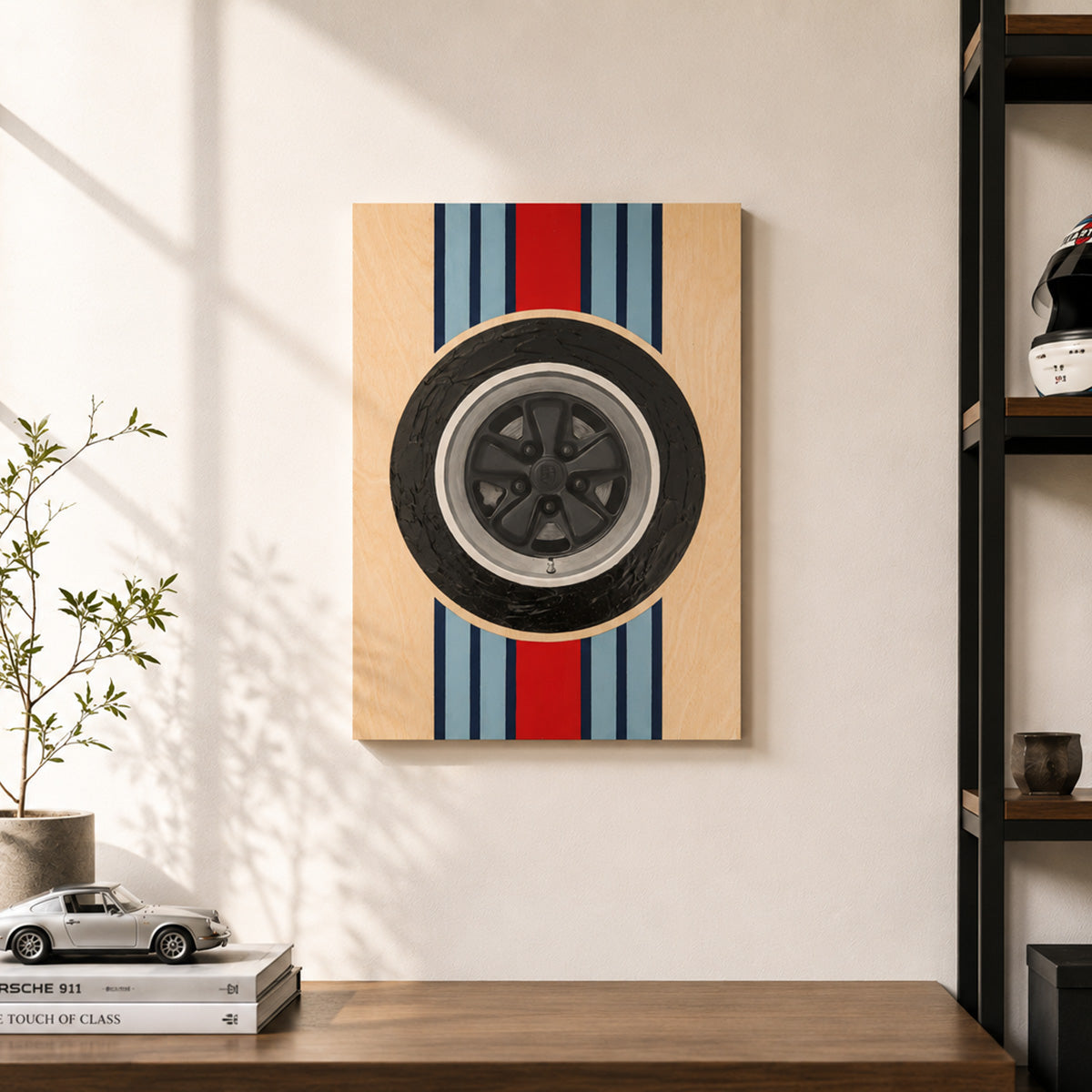 Minimalist Porsche wheel wood panel art with Martini-inspired racing stripes displayed unframed in a bright modern home office, styled above a walnut desk with a model Porsche, racing helmet, and clean architectural shelving.